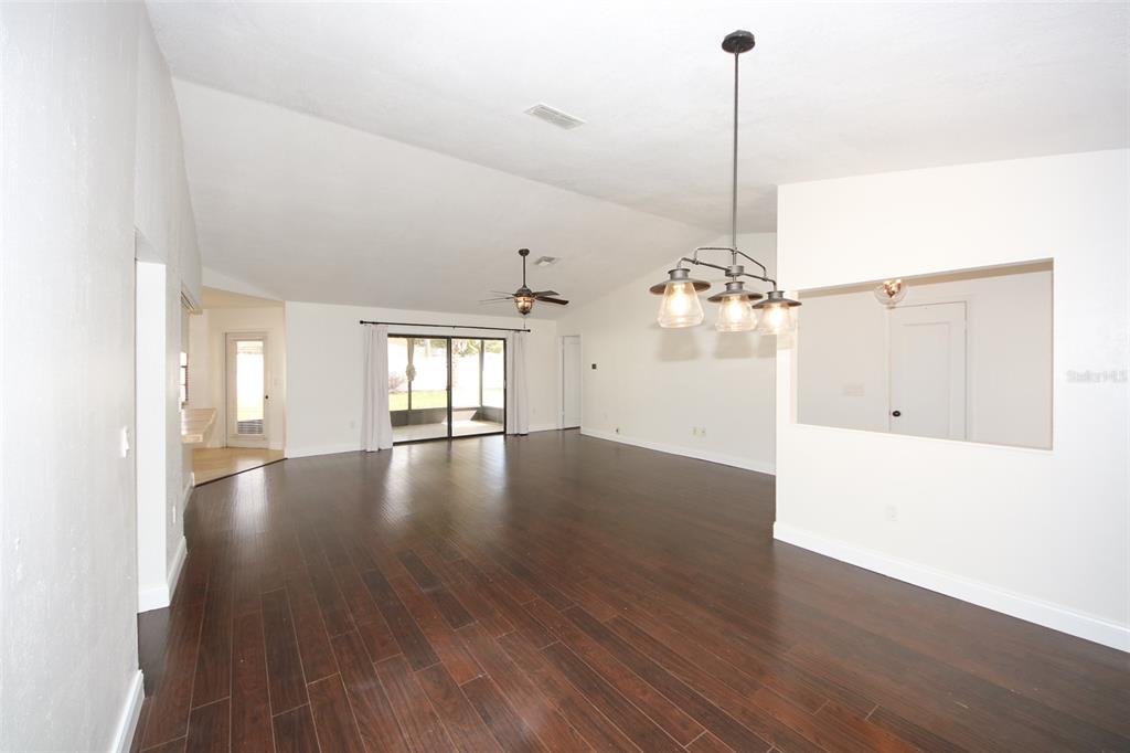 9297 Pickens Street Spring Hill, FL 34608 - Photo 26 of 40 a view of a room with wooden floor chandelier and windows