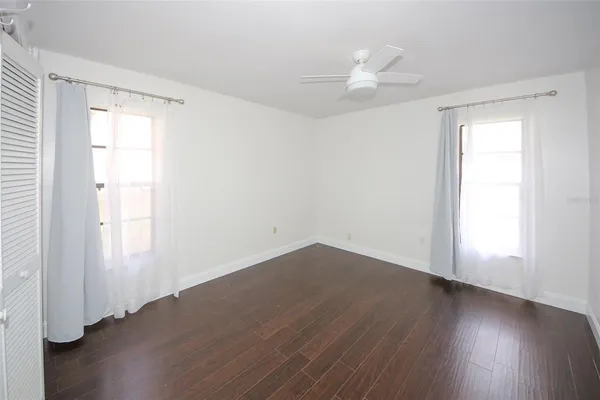 a view of an empty room with wooden floor