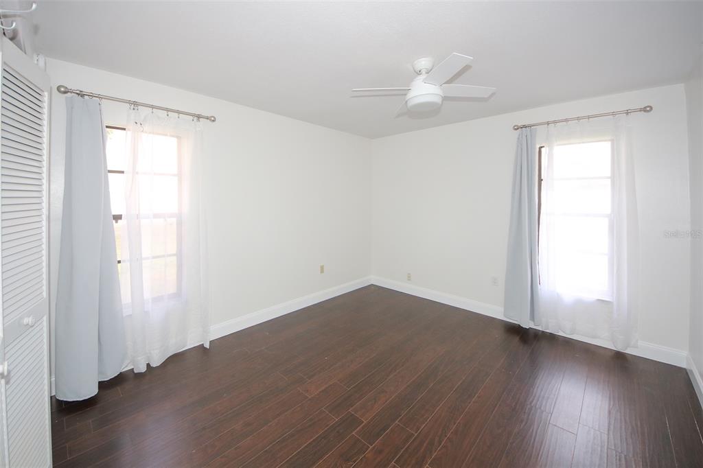 9297 Pickens Street Spring Hill, FL 34608 - Photo 31 of 40 an empty room with wooden floor and windows