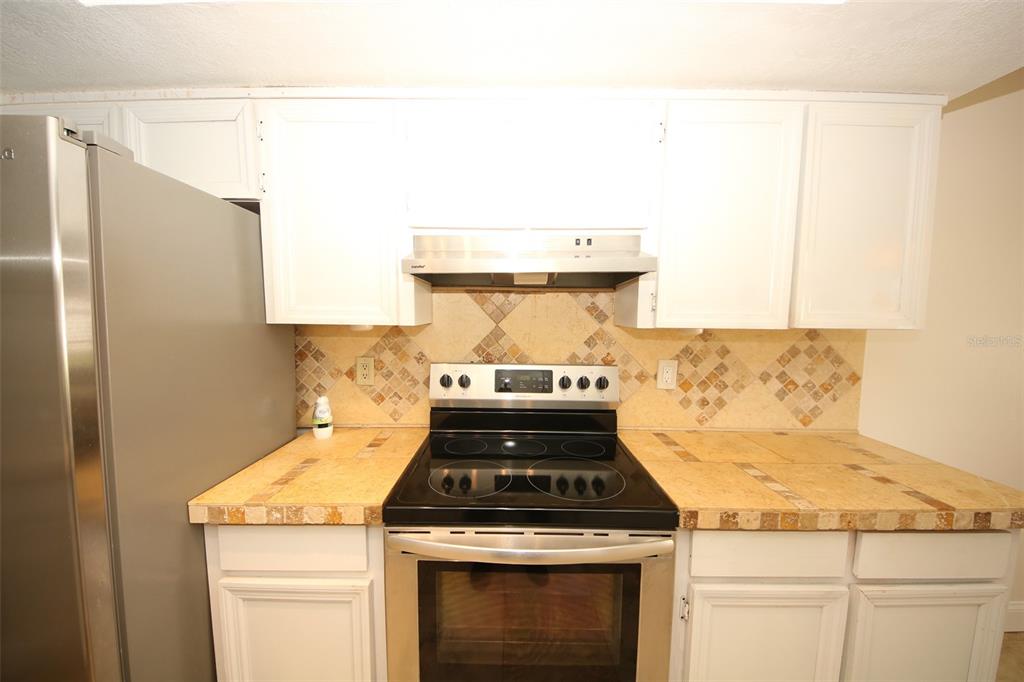 9297 Pickens Street Spring Hill, FL 34608 - Photo 38 of 40 a stove top oven sitting inside of a kitchen