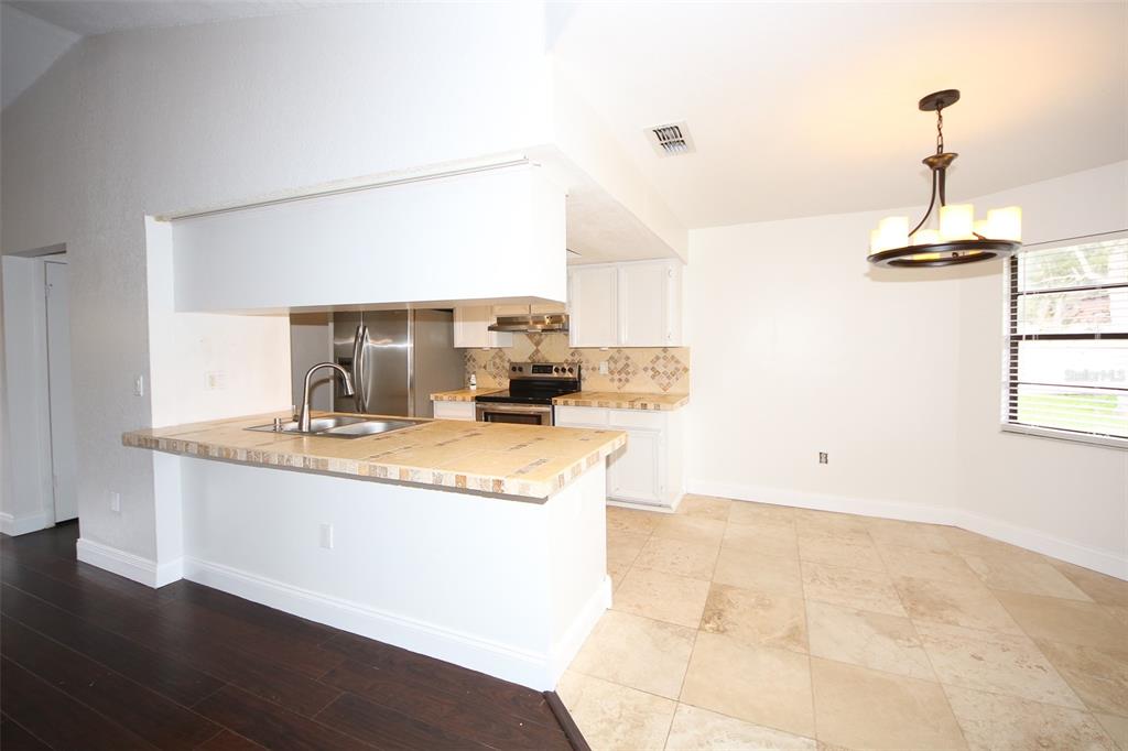 9297 Pickens Street Spring Hill, FL 34608 - Photo 40 of 40 a kitchen with granite countertop a sink a stove and cabinets