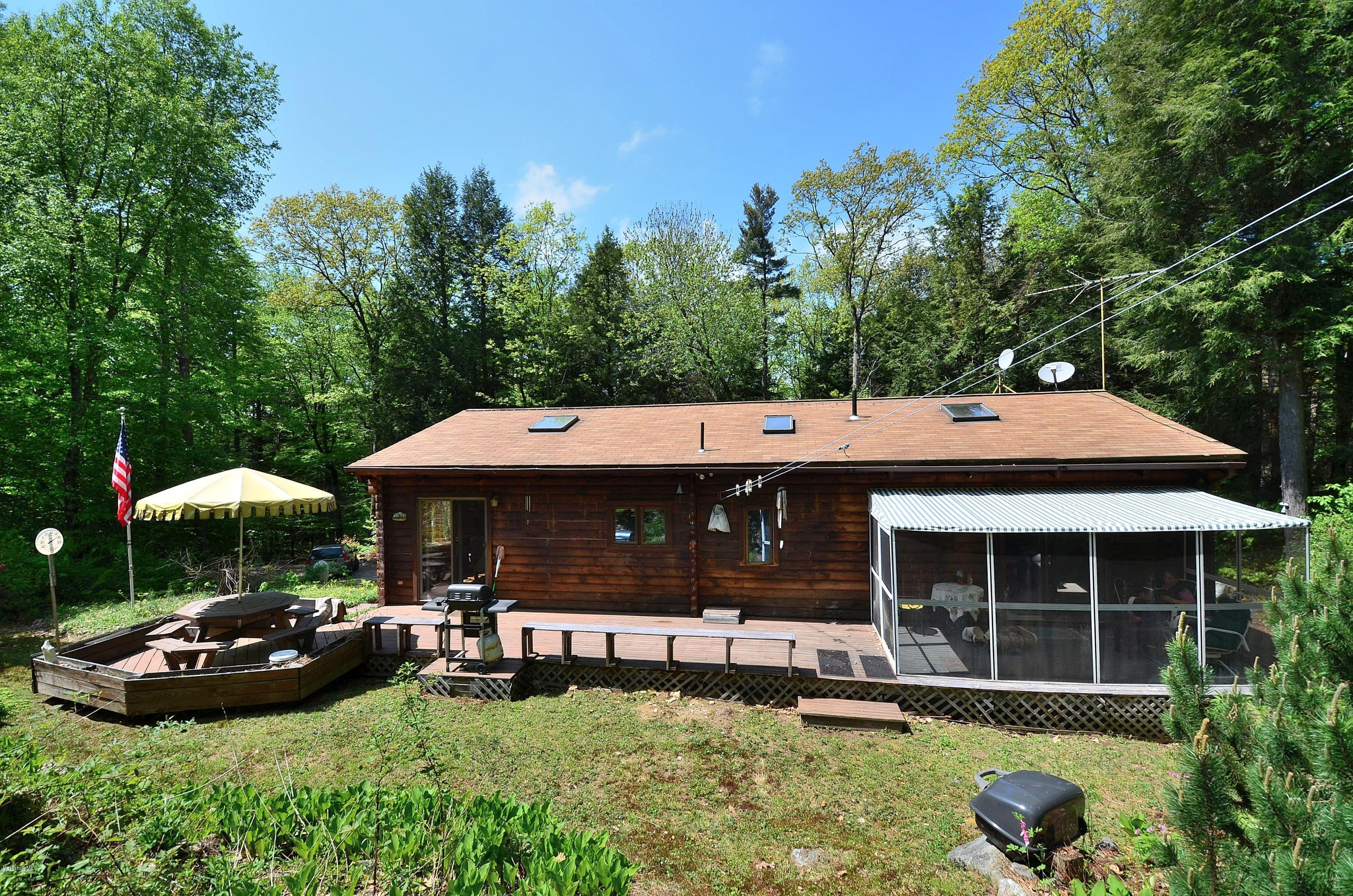 2379 West Center Road Otis, MA 01253 - Photo 14 of 17 a front view of a house with a garden and trees