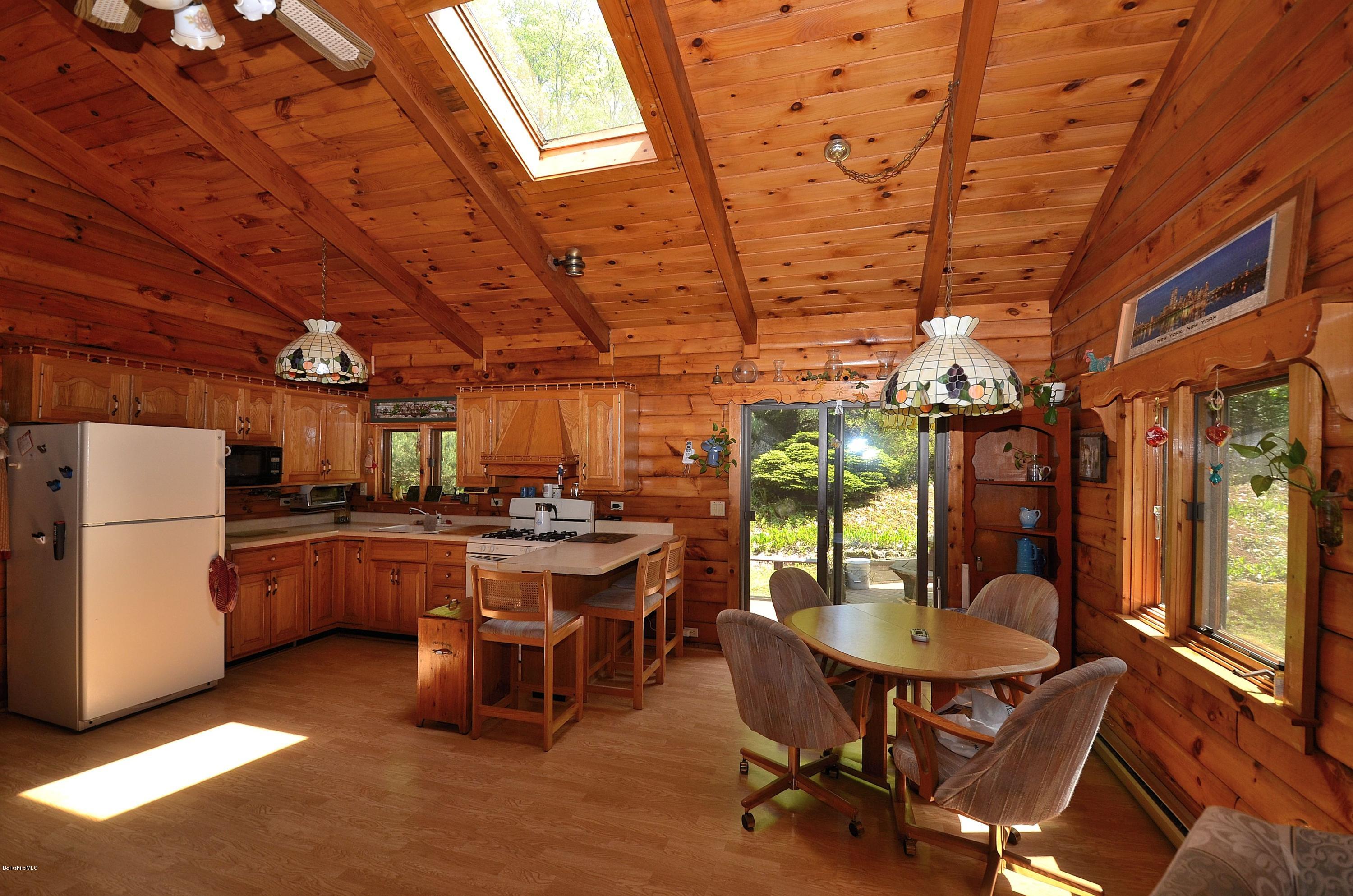 2379 West Center Road Otis, MA 01253 - Photo 4 of 17 a dining room with a wooden table and chairs