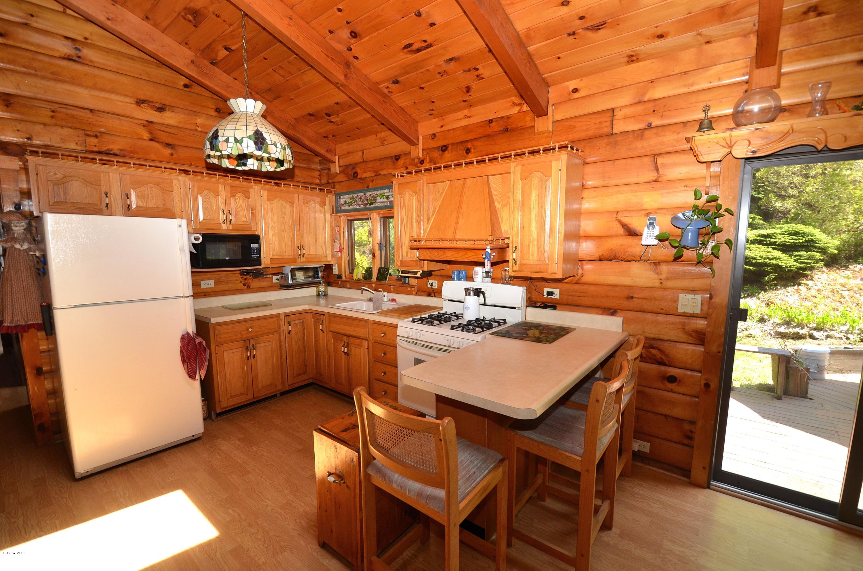 2379 West Center Road Otis, MA 01253 - Photo 5 of 17 a kitchen with a sink a stove and chairs