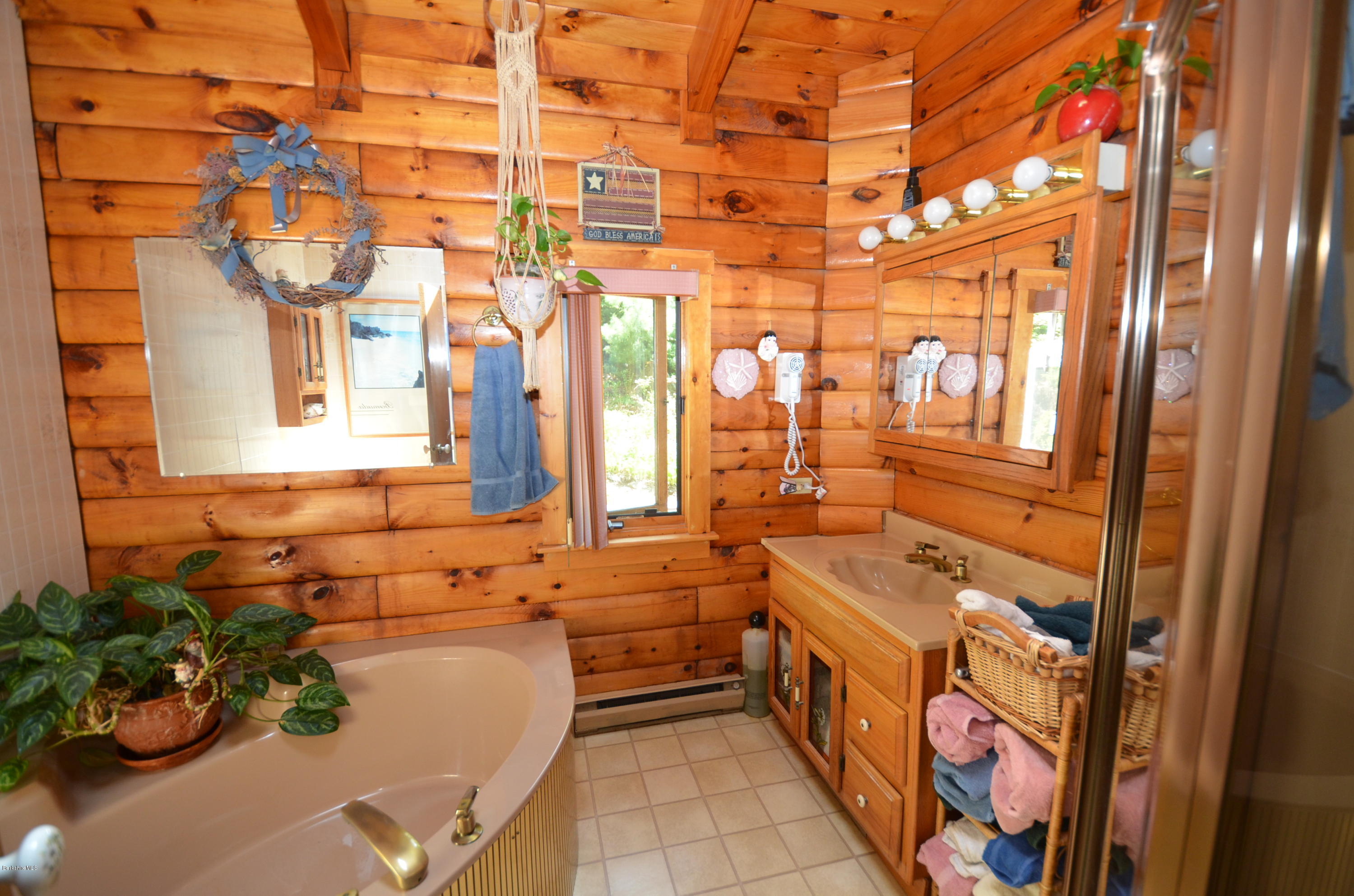2379 West Center Road Otis, MA 01253 - Photo 7 of 17 a bathroom with a tub sink and mirror