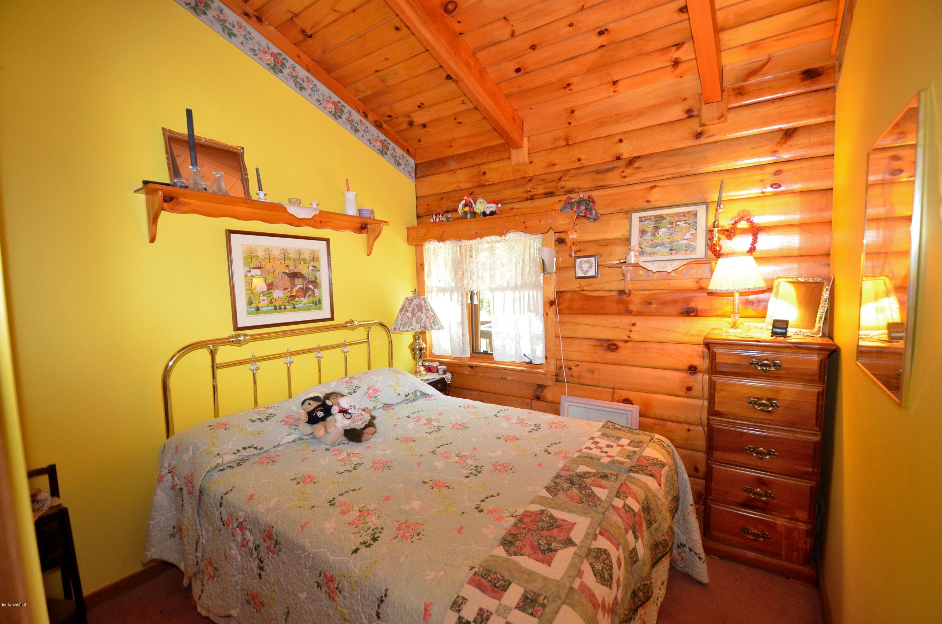2379 West Center Road Otis, MA 01253 - Photo 10 of 17 a bed sitting in a bedroom next to a window