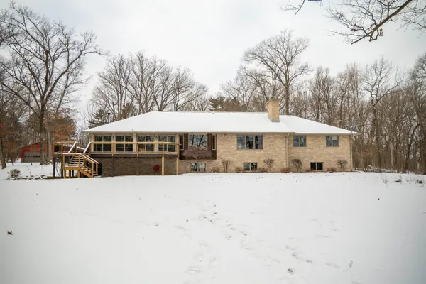 a front view of a house with a yard covered in snow