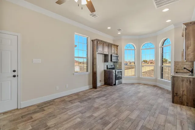 a view of a kitchen with stainless steel appliances granite countertop a refrigerator and a stove top oven