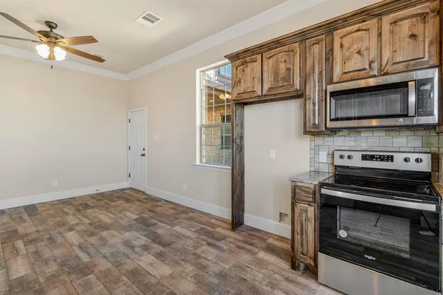 a kitchen with stainless steel appliances granite countertop a stove microwave and cabinets