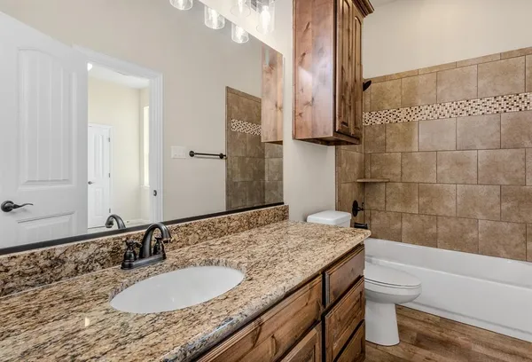 a bathroom with a granite countertop sink toilet and shower