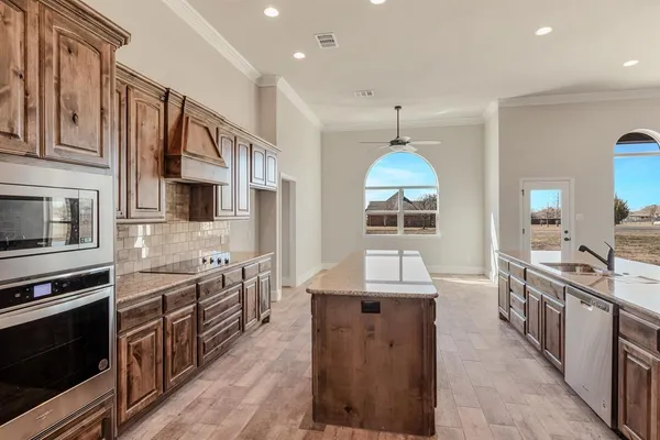 a kitchen with stainless steel appliances granite countertop a sink stove and refrigerator