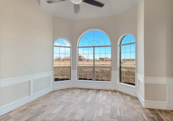 an empty room with a window and a ceiling fan