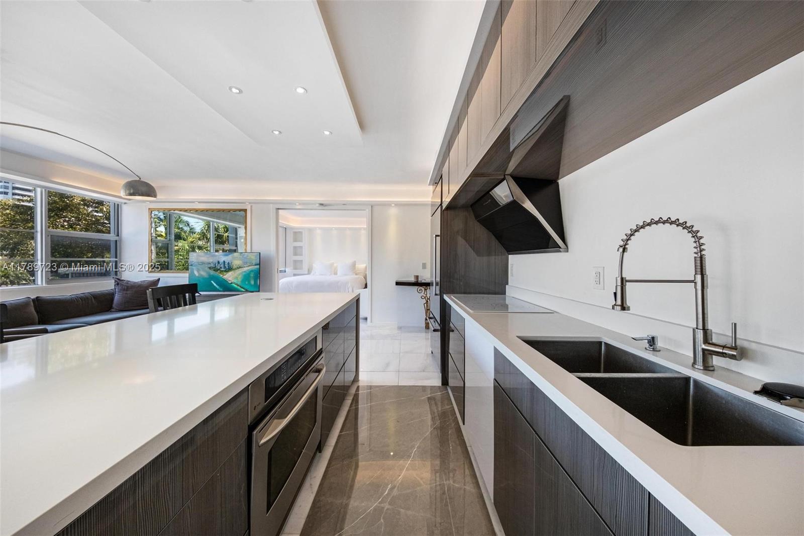 3 Island Avenue, Unit 3C Miami Beach, FL 33139 - Photo 28 of 73 a kitchen with stainless steel appliances a sink a stove and a wooden floors