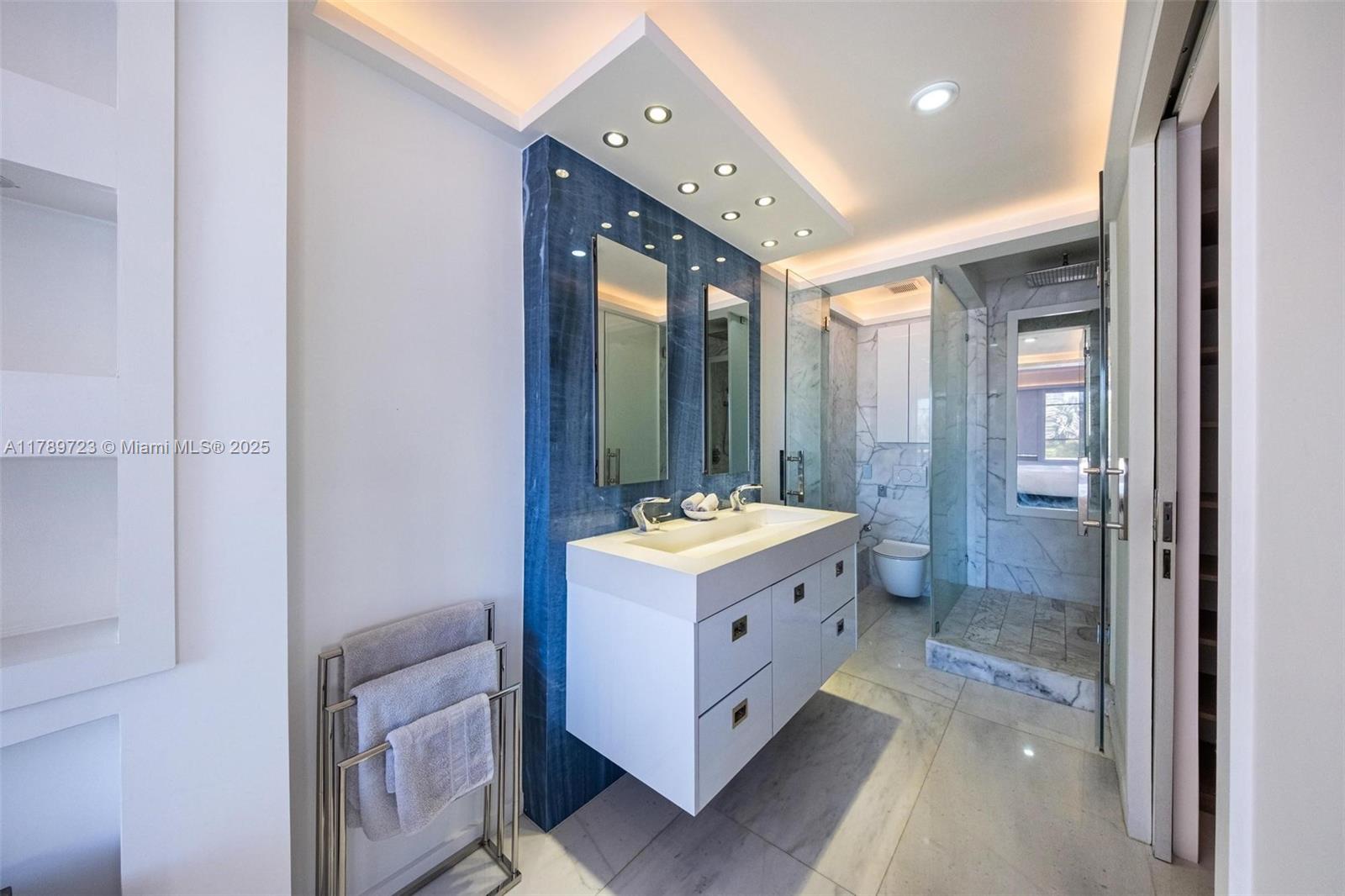 3 Island Avenue, Unit 3C Miami Beach, FL 33139 - Photo 37 of 73 a bathroom with a double vanity sink and mirror with shower