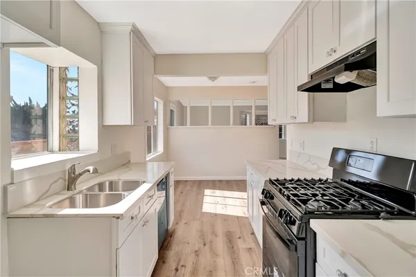 hallway view with wooden floor and windows