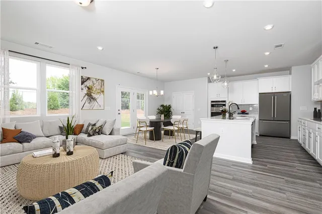 a living room with furniture kitchen and a large window