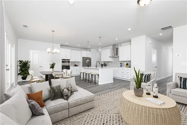 a living room with furniture kitchen and a potted plant