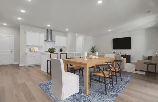 a living room with furniture a flat screen tv and a window