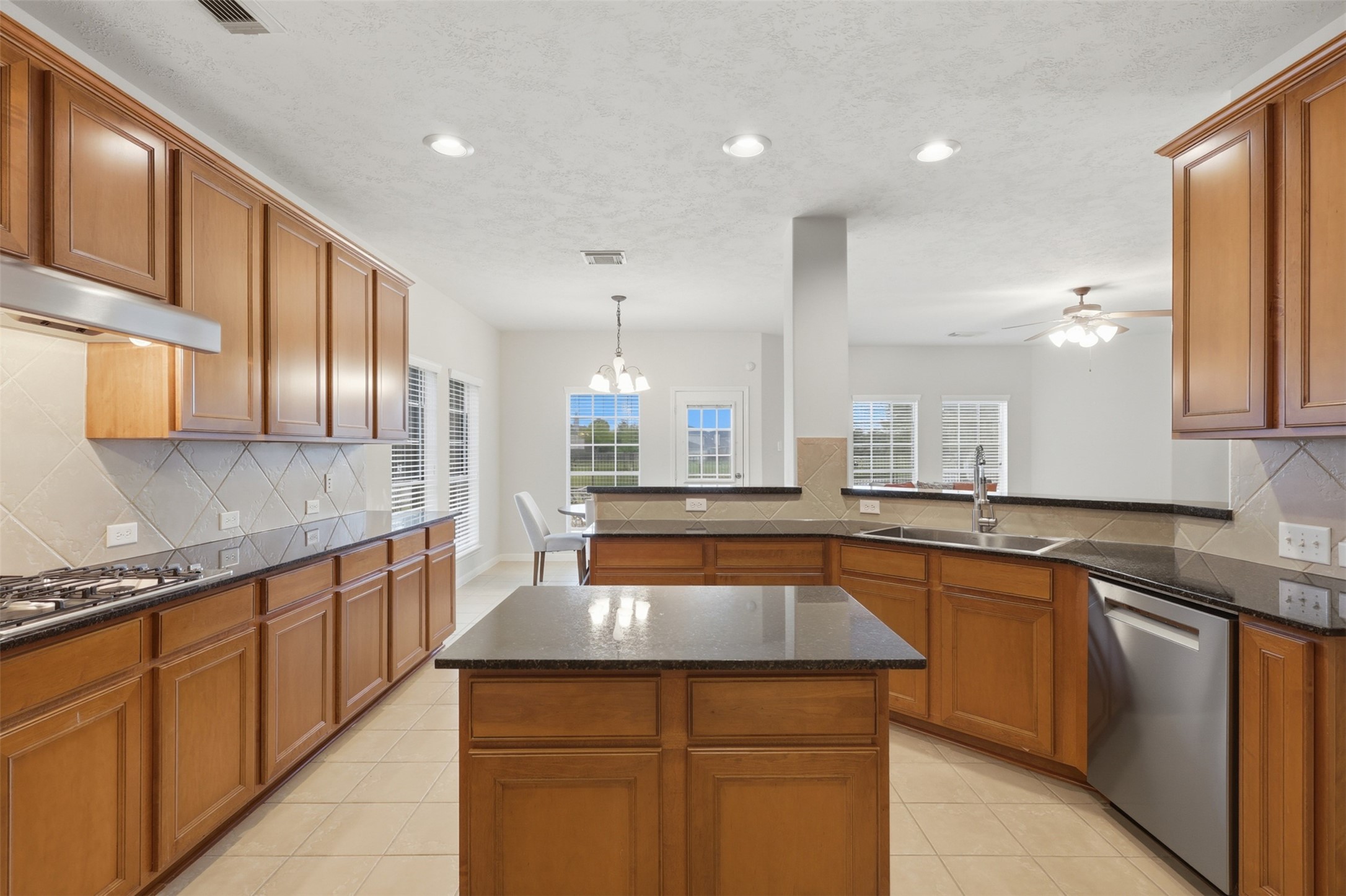 13806 Cove Landing Lane Rosharon, TX 77583 - Photo 12 of 44 The generous kitchen features abundant cabinetry, granite countertops, a center island, recessed lighting, and an open layout.