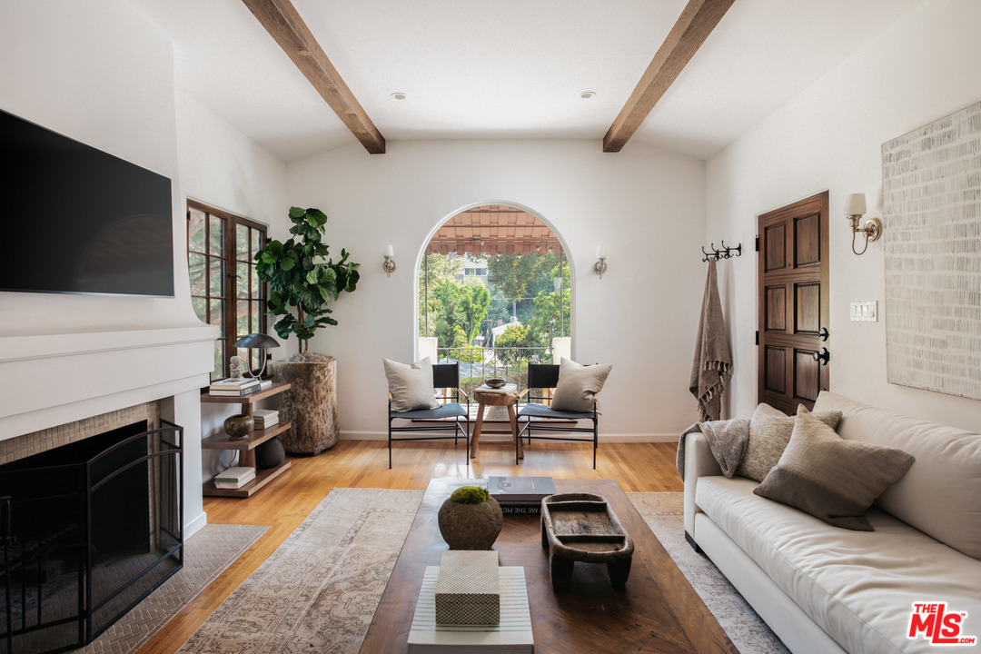 a living room with furniture a large window and a flat screen tv