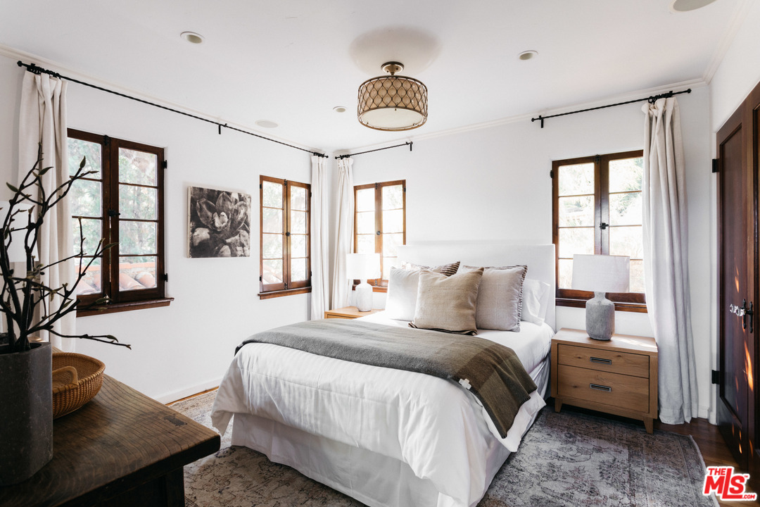 8515 Ridpath Drive Los Angeles, CA 90046 - Photo 15 of 20 a bedroom with a bed and a chandelier