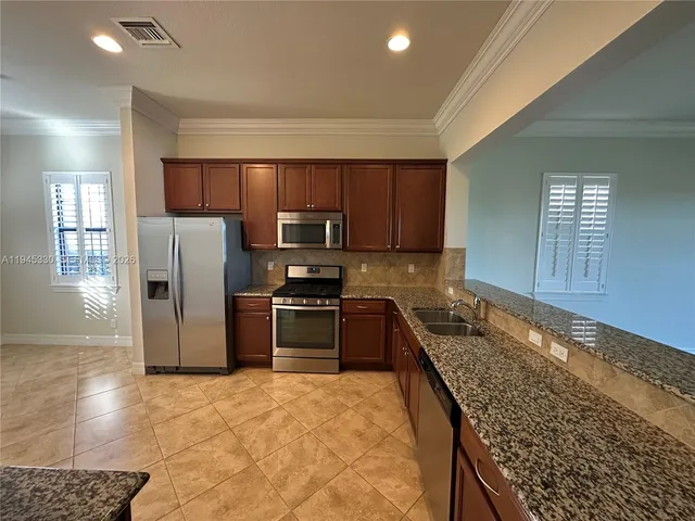 a kitchen with stainless steel appliances granite countertop a refrigerator stove microwave and sink