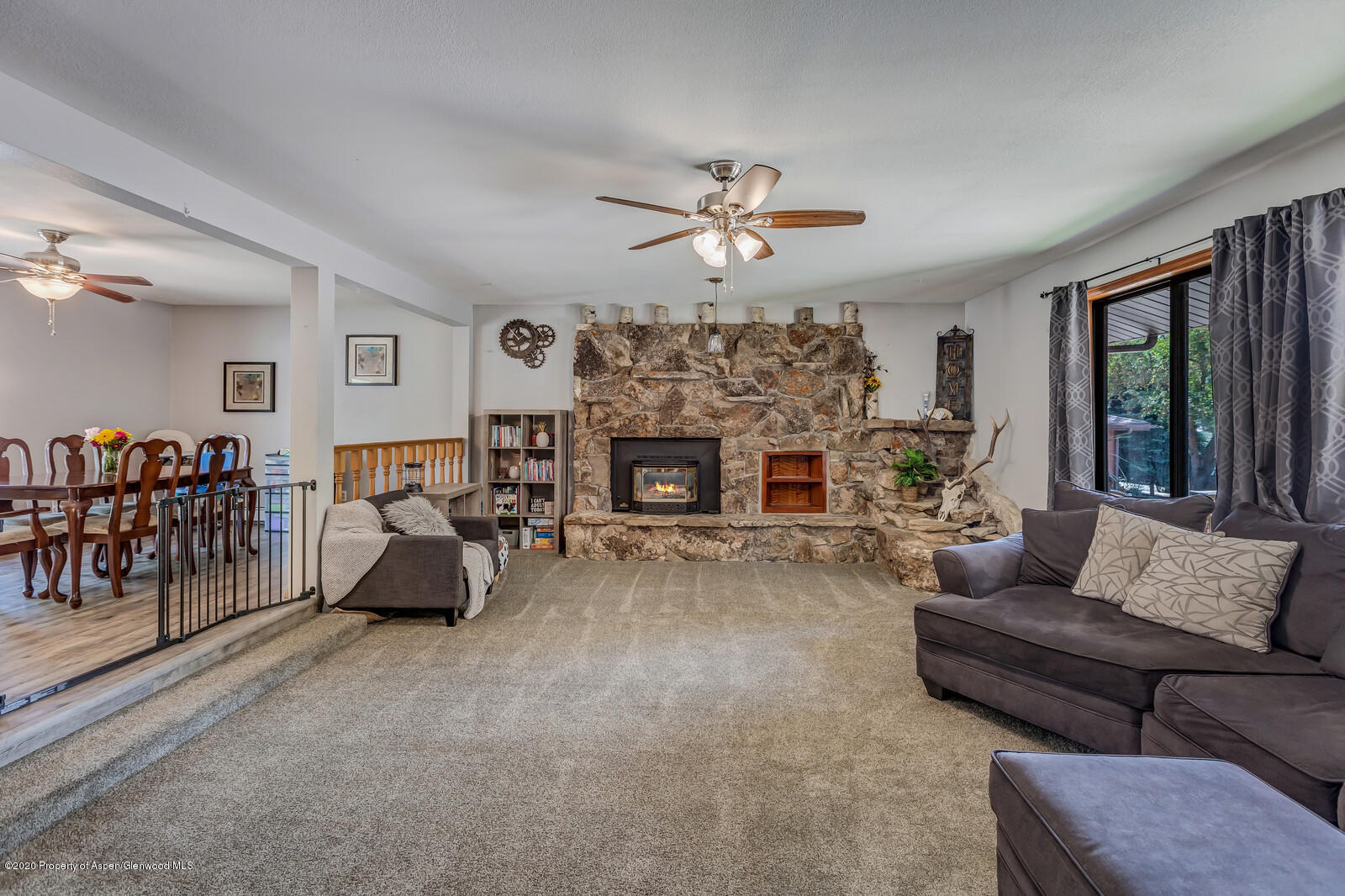 550 Aspen Avenue Rifle, CO 81650 - Photo 4 of 25 a living room with furniture a fireplace and a large window