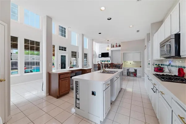 a kitchen with stainless steel appliances kitchen island granite countertop a sink and cabinets