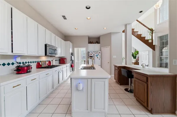 a kitchen with stainless steel appliances kitchen island granite countertop a sink and cabinets