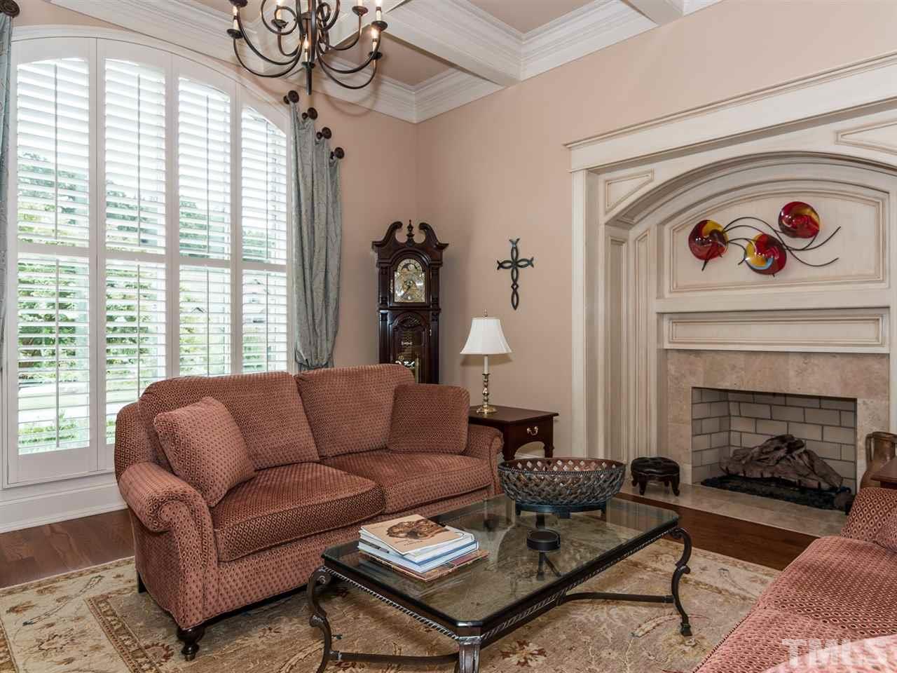 5216 Newstead Manor Lane Raleigh, NC 27606 - Photo 4 of 25 The elegant formal living room has a coffered ceiling, Isokern fireplace and high-end lighting.