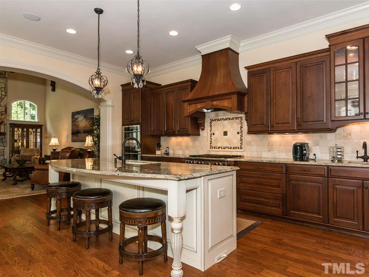 5216 Newstead Manor Lane Raleigh, NC 27606 - Photo 8 of 25 The gourmet kitchen has high-end appliances including a Wolf 6-burner gas range and built-in Subzero refrigerator. The center island has a Grohe Fawcett and high-end granite with OG edging.