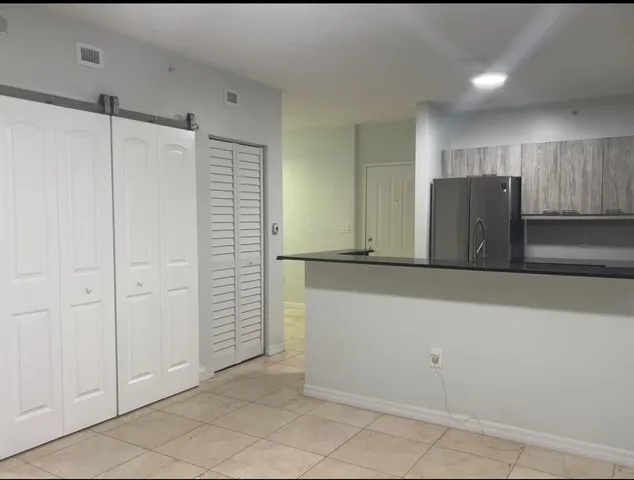 a view of a refrigerator in kitchen and cabinets