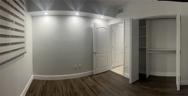 a view of empty room with wooden floor