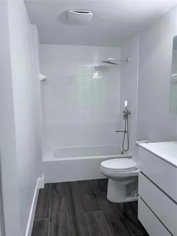 a bathroom with a sink a toilet a mirror and bathtub