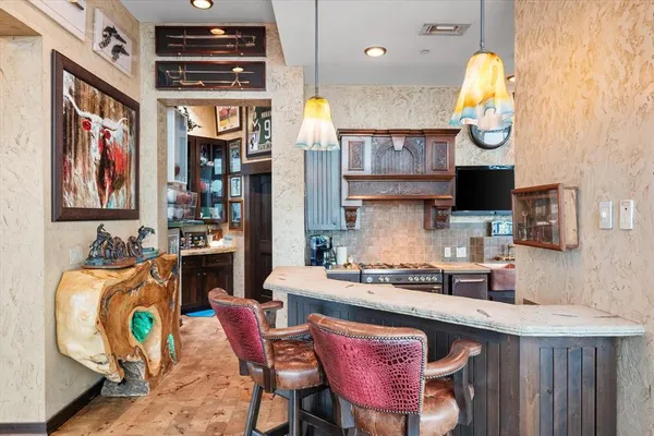 a kitchen with stainless steel appliances granite countertop a stove a sink and a dining table with garden view