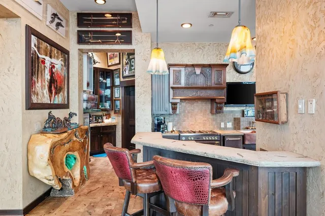 a kitchen with stainless steel appliances granite countertop a stove a sink and a dining table with garden view