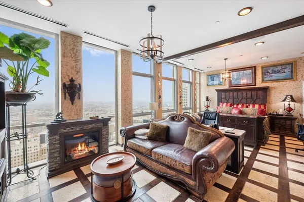 a living room with furniture a fireplace and a chandelier
