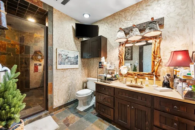 a bathroom with a double vanity sink toilet and shower