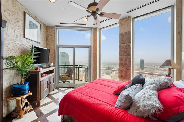 a bedroom with a bed a flat screen tv and balcony