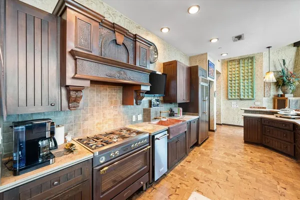 a kitchen with stainless steel appliances granite countertop a stove a sink dishwasher and a refrigerator