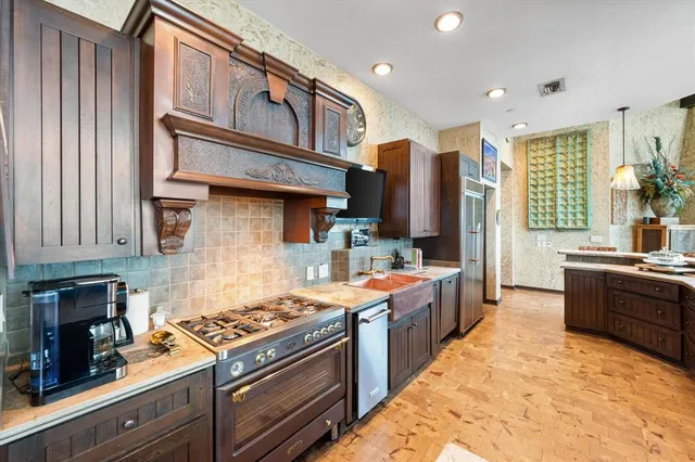 a kitchen with stainless steel appliances granite countertop a stove a sink dishwasher and a refrigerator