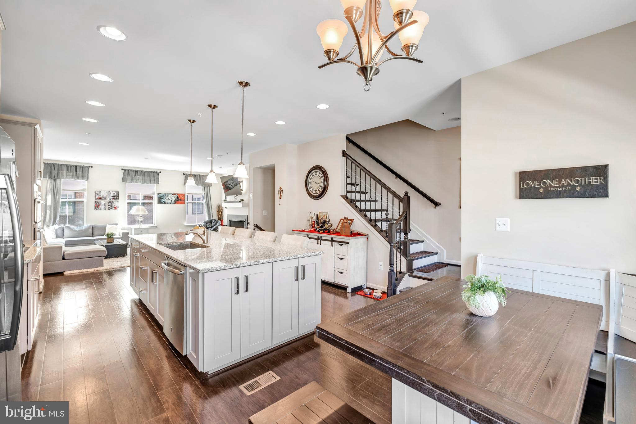 a kitchen with stainless steel appliances granite countertop a sink a stove and chairs