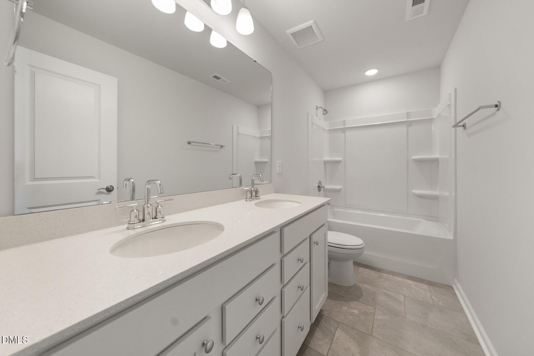 213 Bridle Brk Way Fuquay-Varina, NC 27526 - Photo 21 of 25 a bathroom with a sink a toilet a shower and a mirror