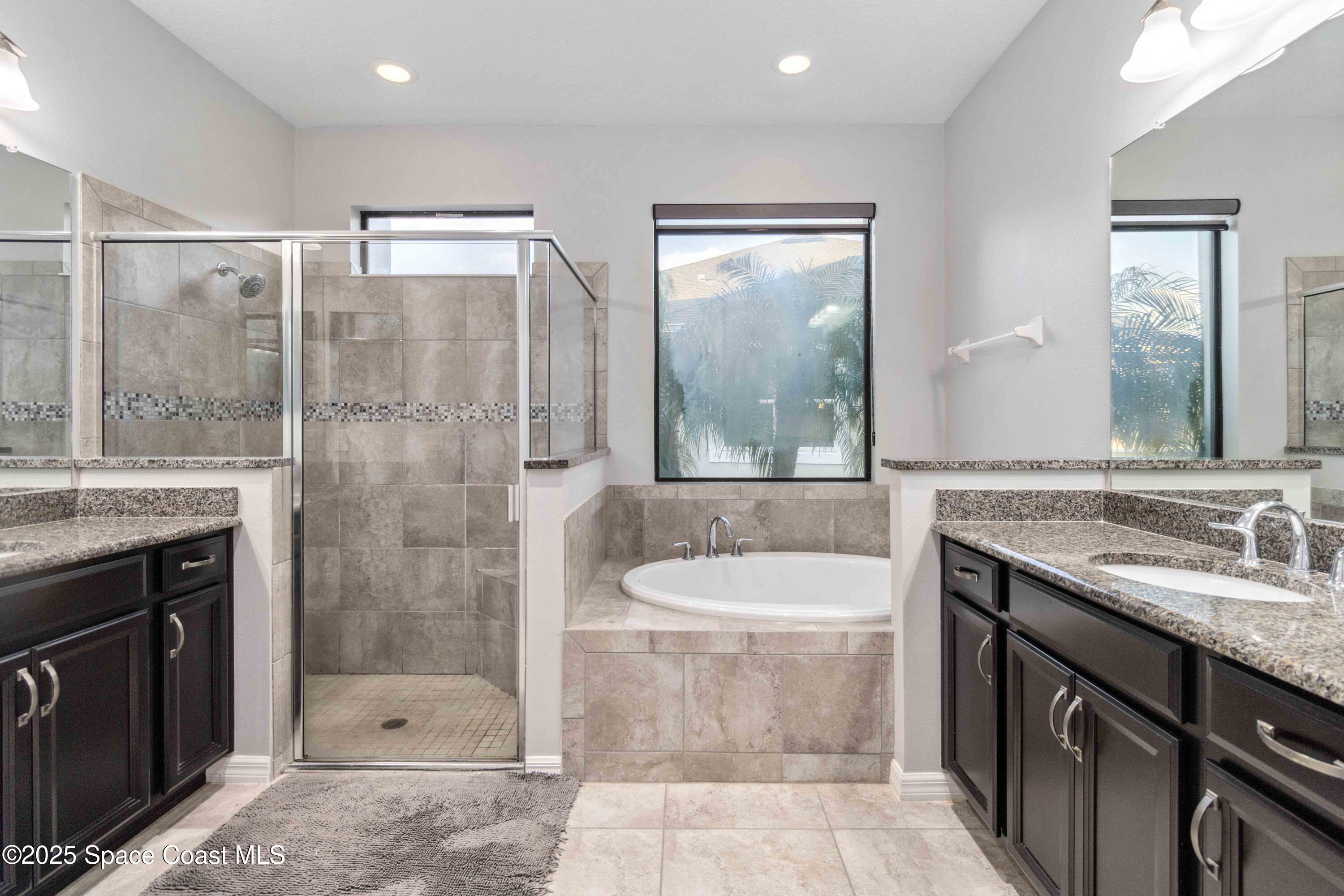 7565 Millbrook Avenue Melbourne, FL 32940 - Photo 17 of 47 a bathroom with a granite countertop sink a toilet a mirror and shower