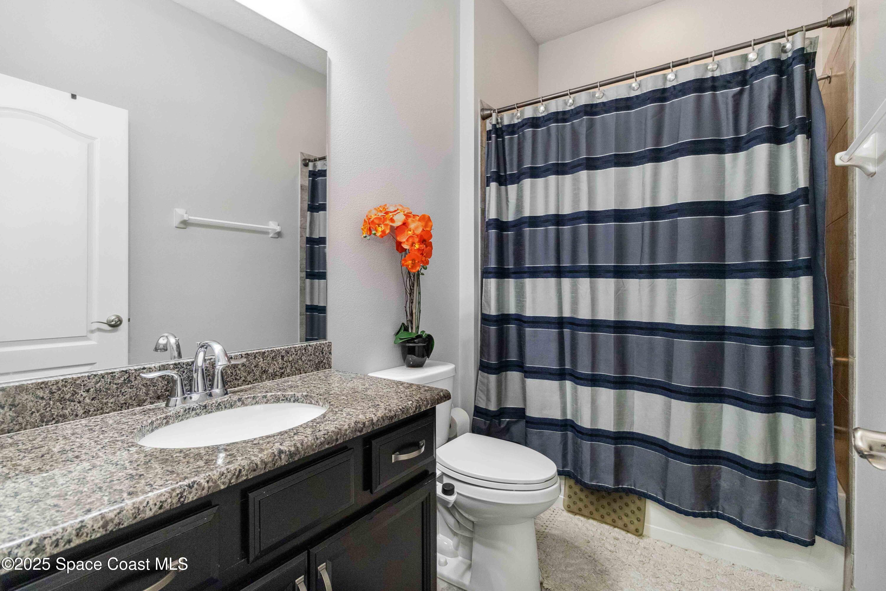 7565 Millbrook Avenue Melbourne, FL 32940 - Photo 19 of 47 a bathroom with a granite countertop sink and a mirror