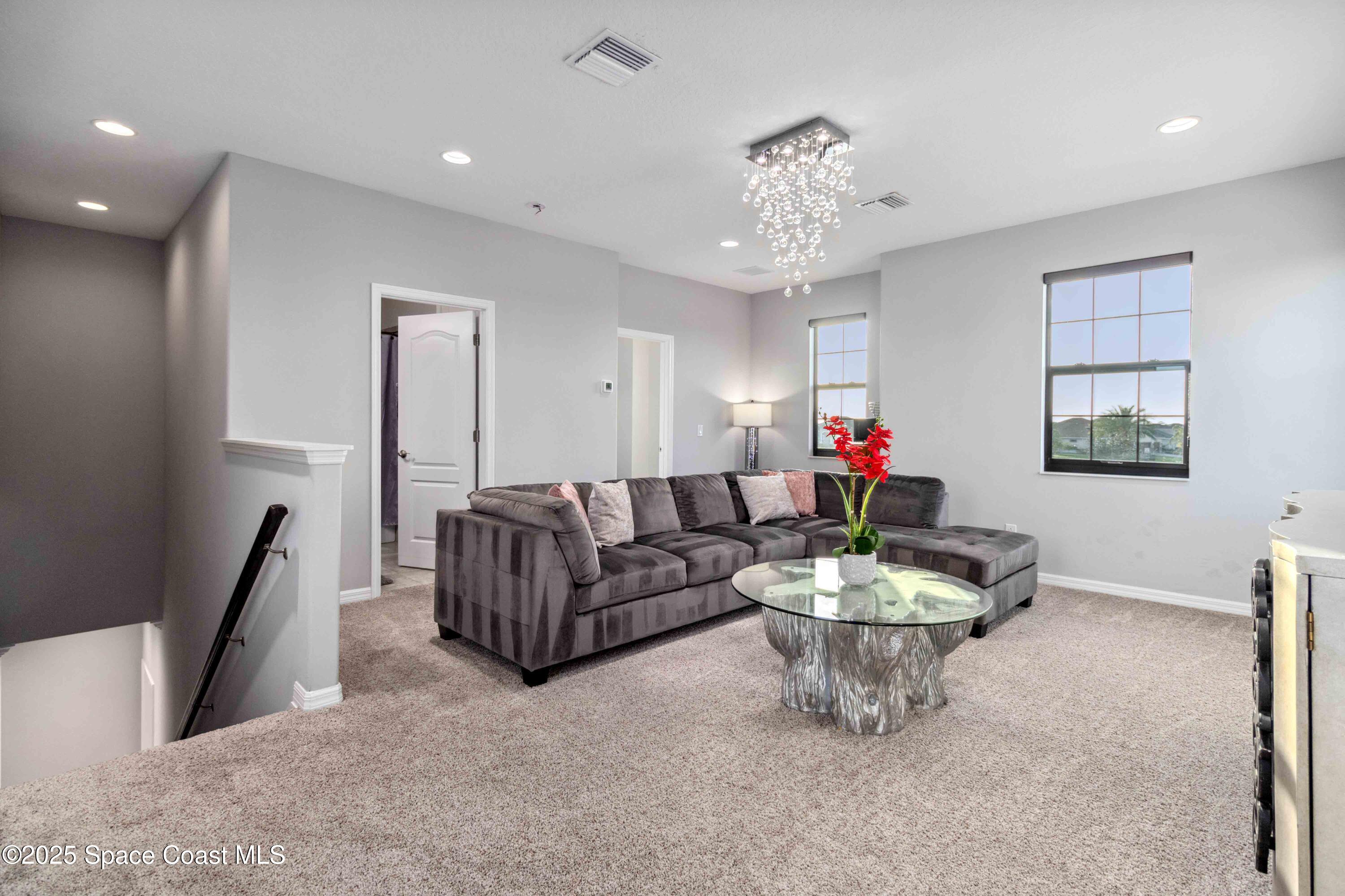 7565 Millbrook Avenue Melbourne, FL 32940 - Photo 25 of 47 a living room with fireplace furniture and a chandelier