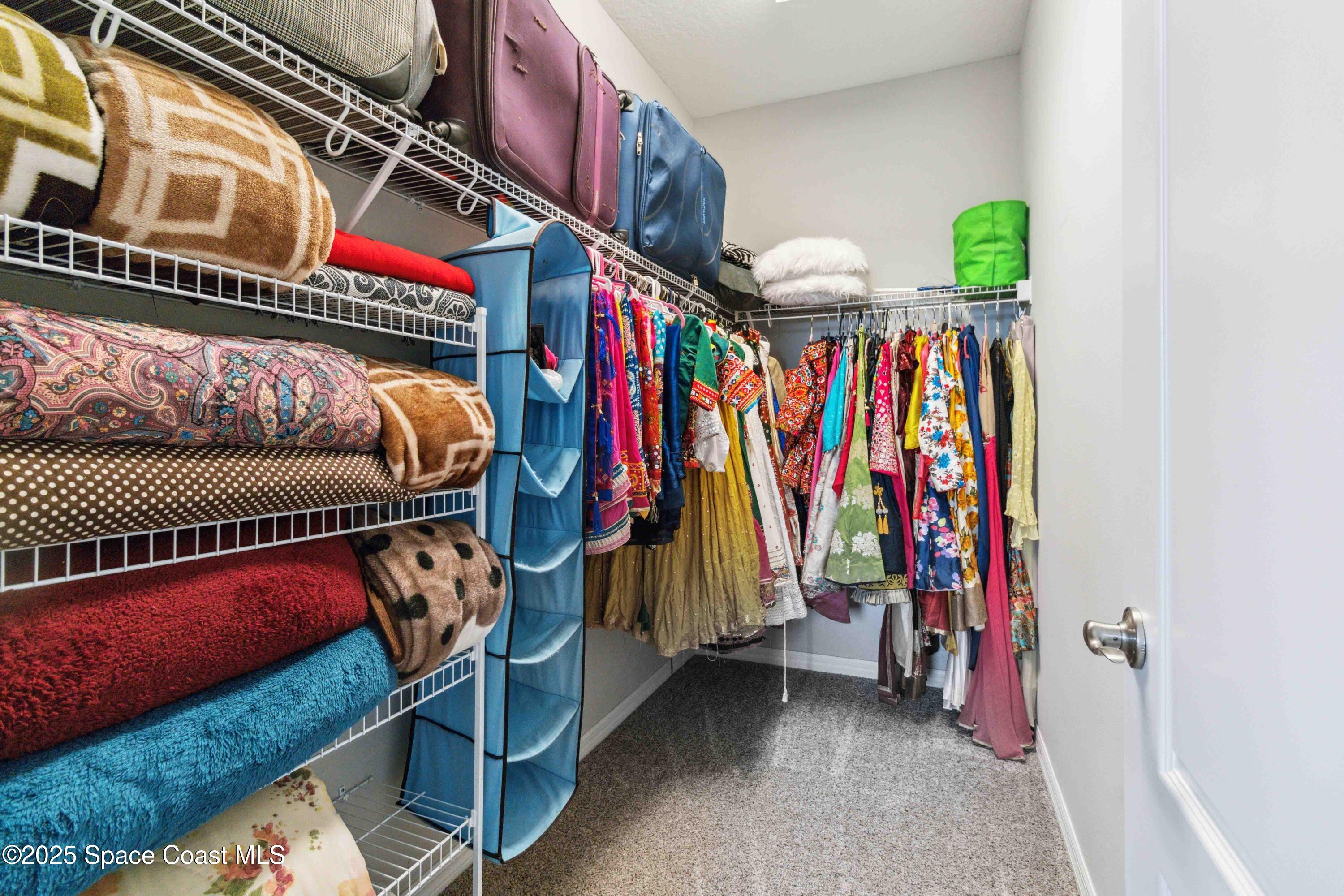 7565 Millbrook Avenue Melbourne, FL 32940 - Photo 27 of 47 a view of walk in closet with clothes and shoes