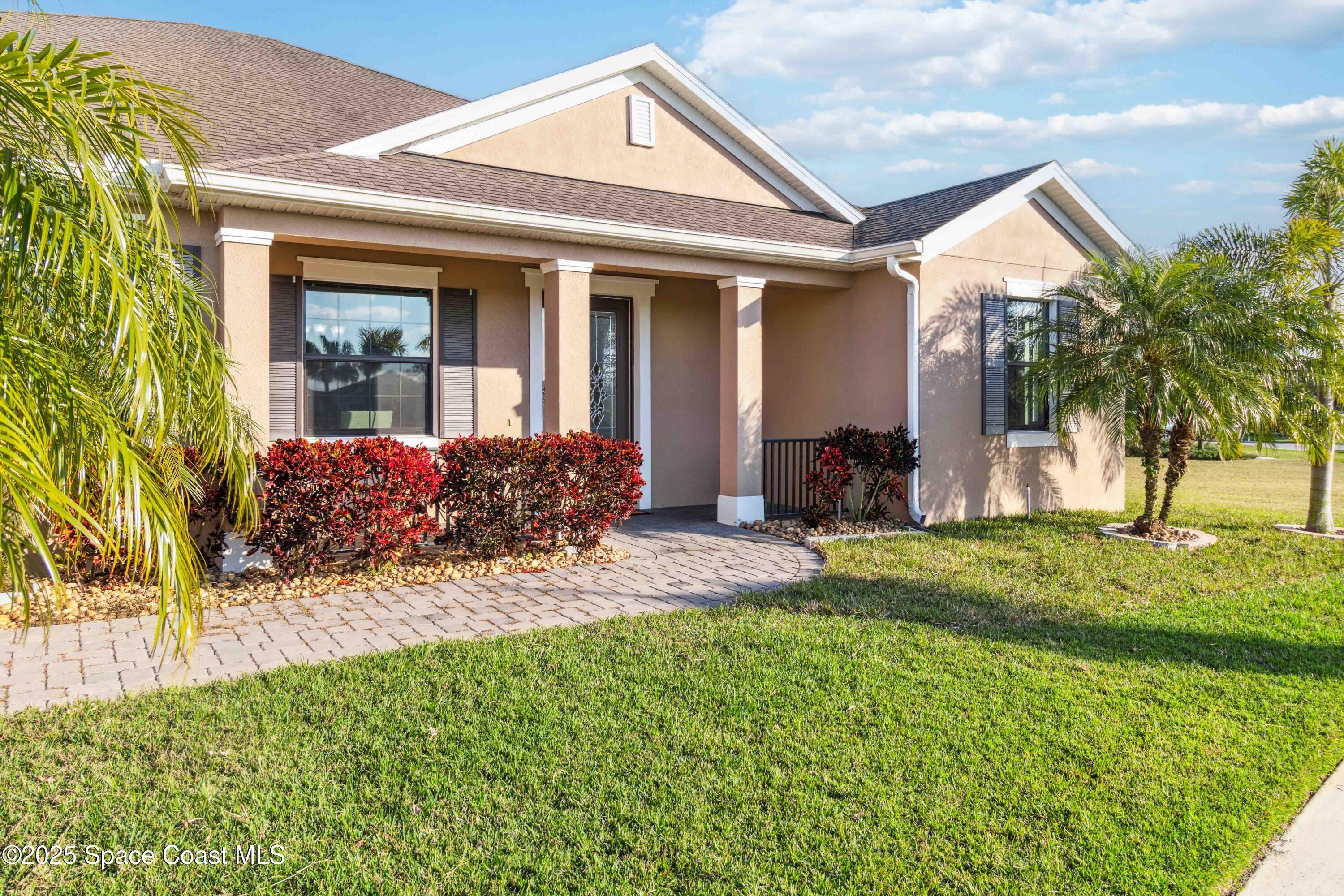 7565 Millbrook Avenue Melbourne, FL 32940 - Photo 3 of 47 a front view of a house with garden