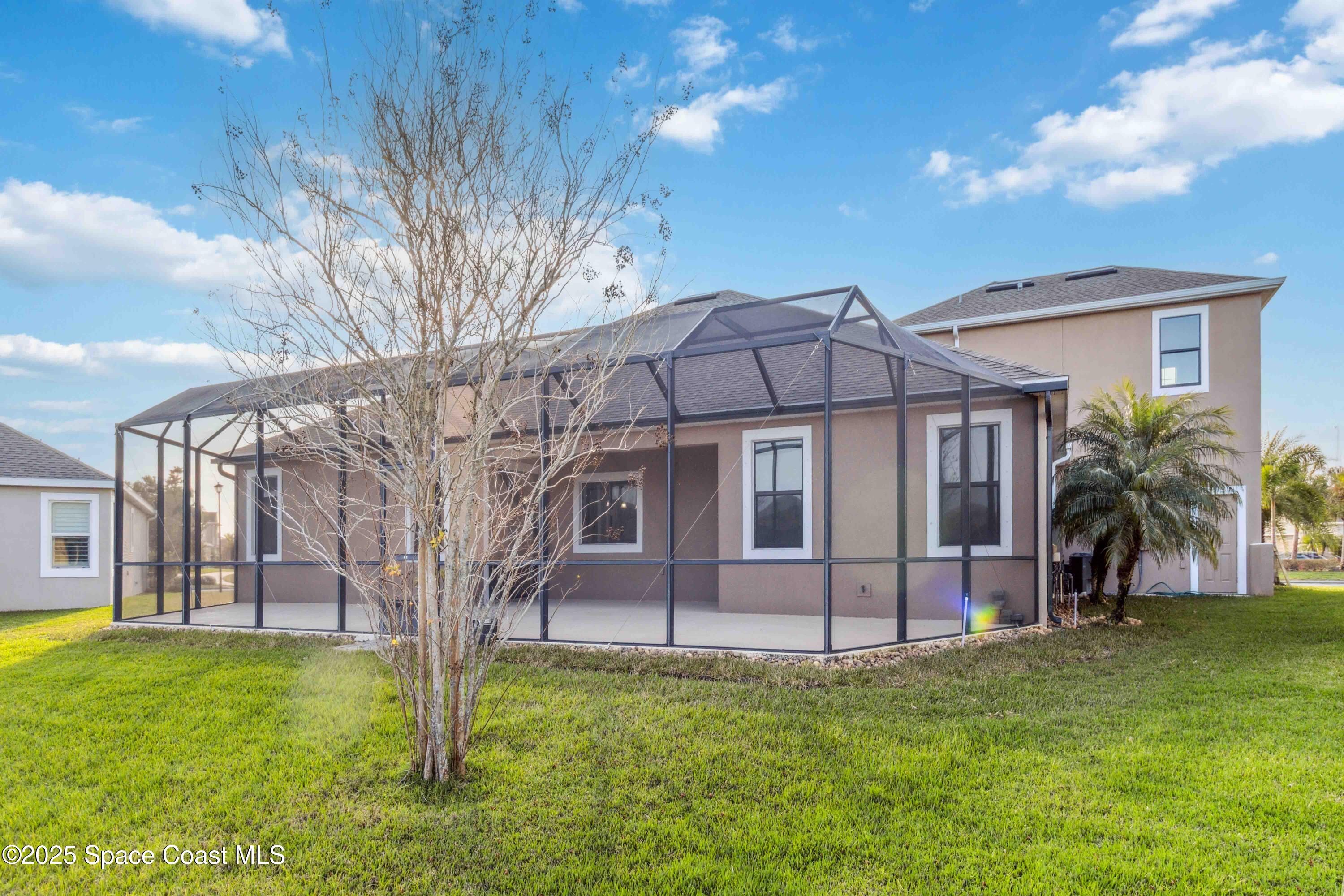 7565 Millbrook Avenue Melbourne, FL 32940 - Photo 33 of 47 a view of a house with a backyard