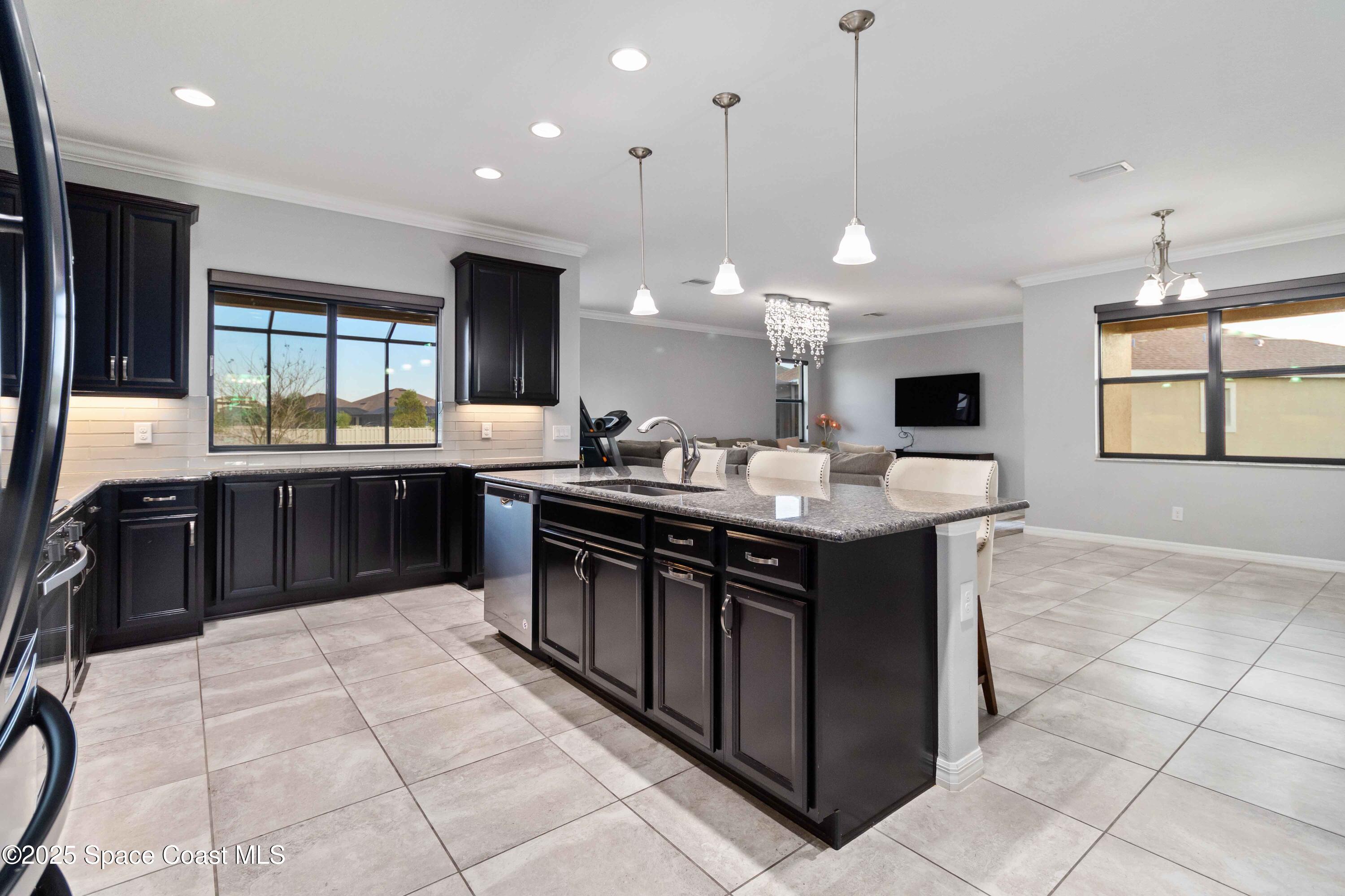 7565 Millbrook Avenue Melbourne, FL 32940 - Photo 8 of 47 a kitchen with a stove sink and cabinets